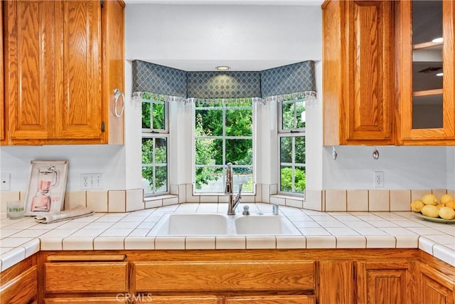 9818 Capulet Ave, Whittier, CA 90603 - kitchen with a sink, brown cabinetry, and glass insert cabinets
