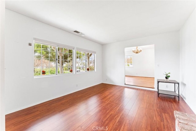 9818 Capulet Ave, Whittier, CA 90603 - empty room with healthy amount of natural light, a chandelier, and wood finished floors
