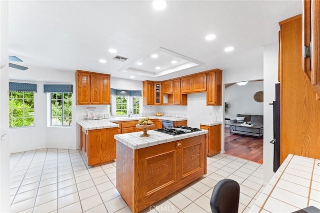 9818 Capulet Ave, Whittier, CA 90603 - kitchen featuring tile countertops, brown cabinetry, gas stovetop, recessed lighting, and light tile patterned flooring