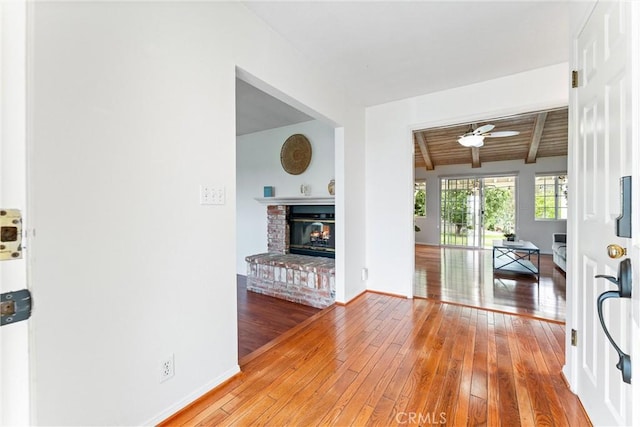9818 Capulet Ave, Whittier, CA 90603 - living room featuring hardwood / wood-style floors, a brick fireplace, baseboards, ceiling fan, and wood ceiling