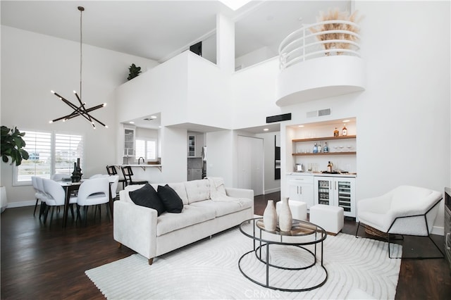 1617 S Beverly Glen Blvd Unit 301, Los Angeles, CA 90024 - living room featuring beverage cooler, a bar, a chandelier, wood finished floors, and baseboards