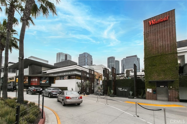 1617 S Beverly Glen Blvd Unit 301, Los Angeles, CA 90024 - view of asphalt road featuring curbs, sidewalks, a view of skyline, and street lighting