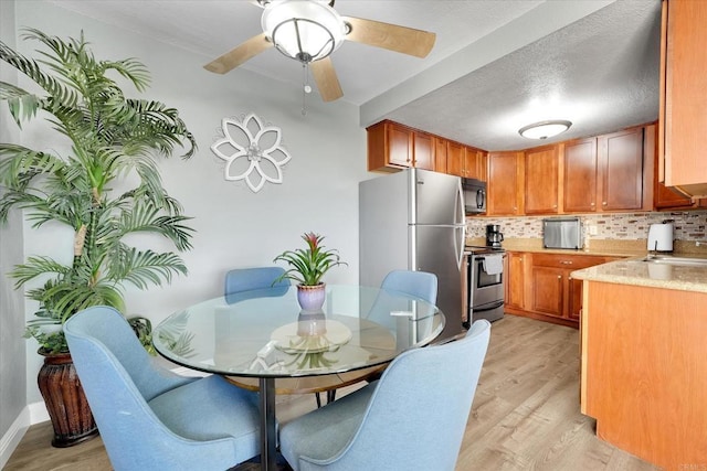 12719 Robison Blvd Unit 18, Poway, CA 92064 - kitchen with stainless steel appliances, light countertops, light wood-style floors, and decorative backsplash