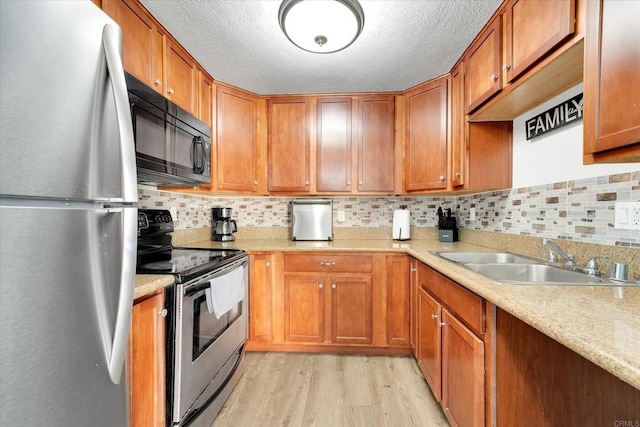 12719 Robison Blvd Unit 18, Poway, CA 92064 - kitchen featuring stainless steel appliances, a sink, light wood finished floors, light countertops, and brown cabinetry