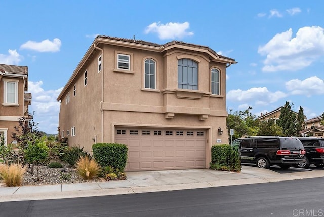 18861 Caminito Cantilena Unit 26, San Diego, CA 92128 - view of front of home featuring stucco siding, an attached garage, and driveway