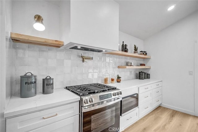 2842 E Virginia Ave, Anaheim, CA 92806 - kitchen with stainless steel gas stove, white cabinetry, light wood finished floors, decorative backsplash, and lofted ceiling