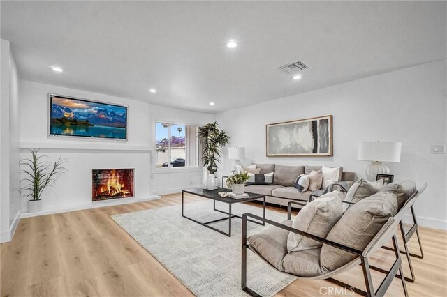 2842 E Virginia Ave, Anaheim, CA 92806 - living area featuring recessed lighting, light wood-style flooring, baseboards, and a warm lit fireplace