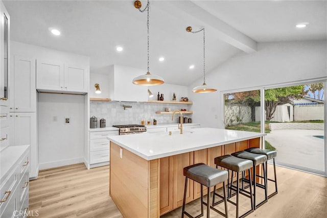 2842 E Virginia Ave, Anaheim, CA 92806 - kitchen with stainless steel range, tasteful backsplash, light countertops, light wood finished floors, and a sink
