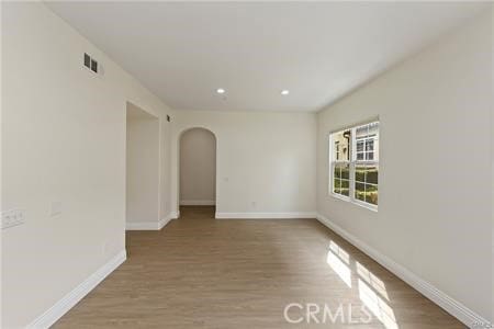 4304 Owens St Unit 102, Corona, CA 92883 - empty room featuring arched walkways, wood finished floors, and recessed lighting