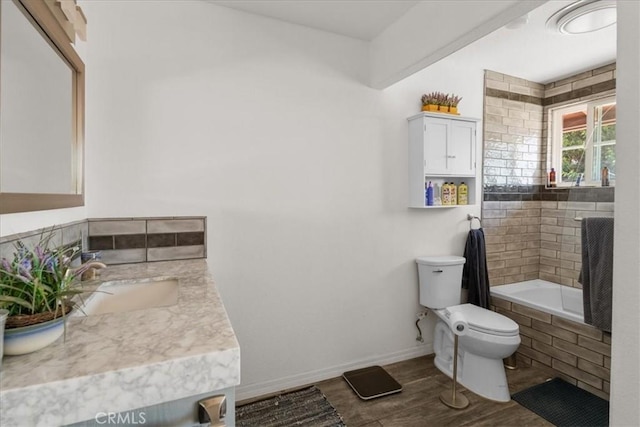 22025 Del Oro Rd, Apple Valley, CA 92308 - bathroom featuring toilet, vanity, wood finished floors, tiled shower / bath, and baseboards