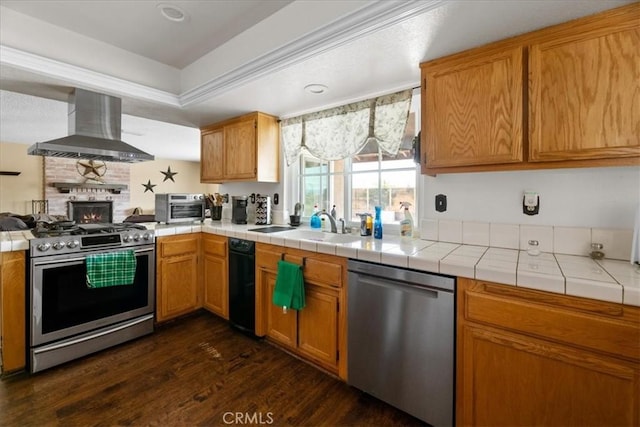 22025 Del Oro Rd, Apple Valley, CA 92308 - kitchen with wall chimney range hood, appliances with stainless steel finishes, dark wood-style floors, open floor plan, and tile counters
