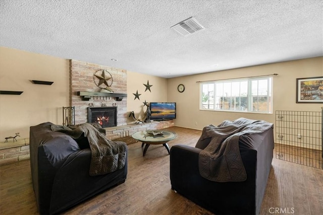 22025 Del Oro Rd, Apple Valley, CA 92308 - living room featuring wood finished floors, a fireplace, and a textured ceiling