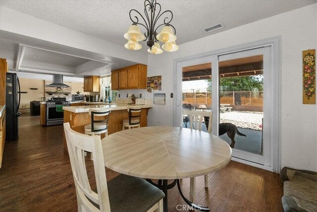 22025 Del Oro Rd, Apple Valley, CA 92308 - dining area with dark wood-style flooring, a chandelier, healthy amount of natural light, a tray ceiling, and a textured ceiling