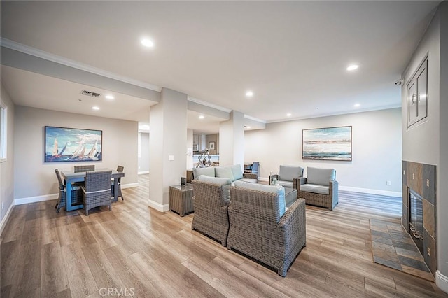 1500 E Ocean Blvd Unit 419, Long Beach, CA 90802 - living room with light wood-style flooring, ornamental molding, baseboards, recessed lighting, and a glass covered fireplace