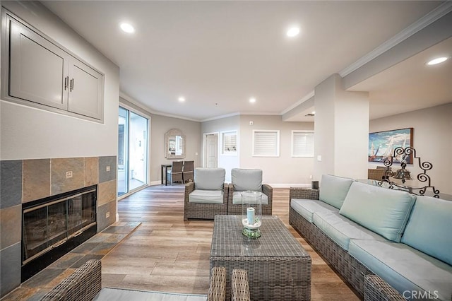 1500 E Ocean Blvd Unit 419, Long Beach, CA 90802 - living room featuring crown molding, light wood finished floors, recessed lighting, baseboards, and a tile fireplace