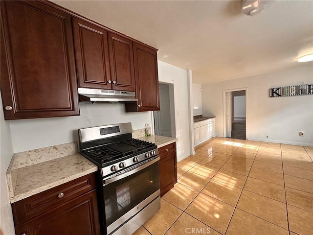 3208 W 74th St, Los Angeles, CA 90043 - kitchen featuring stainless steel gas stove, under cabinet range hood, light tile patterned floors, and light stone countertops