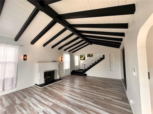 3208 W 74th St, Los Angeles, CA 90043 - unfurnished living room with arched walkways, plenty of natural light, wood finished floors, and stairway