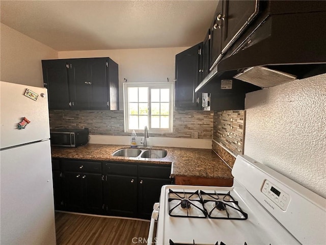 3208 W 74th St, Los Angeles, CA 90043 - kitchen with white appliances, dark cabinetry, under cabinet range hood, tasteful backsplash, and dark wood finished floors