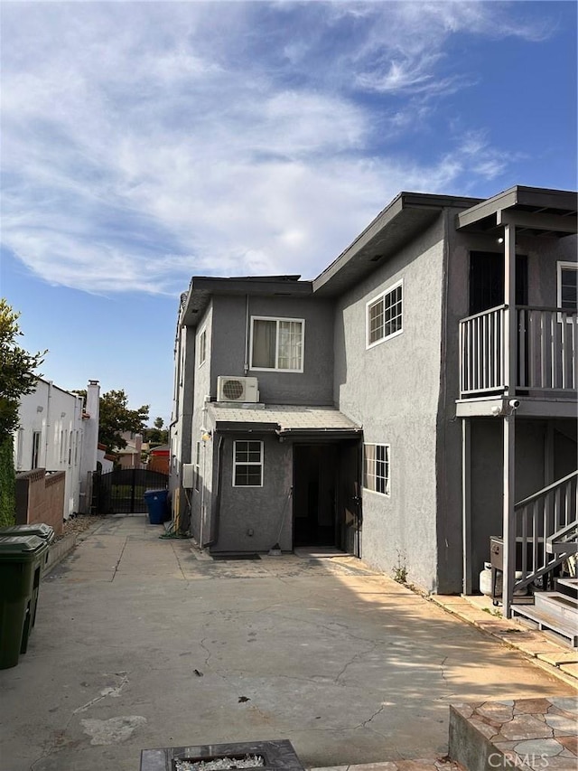 3208 W 74th St, Los Angeles, CA 90043 - rear view of house with stucco siding, a patio area, and a balcony