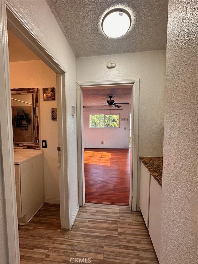 3208 W 74th St, Los Angeles, CA 90043 - hallway featuring wood finished floors, a textured ceiling, and a textured wall