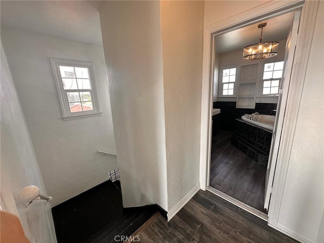 3208 W 74th St, Los Angeles, CA 90043 - bathroom with wood finished floors, a bath, and a chandelier