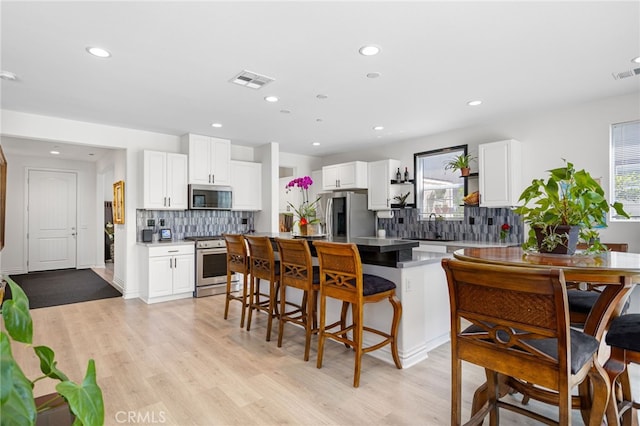 36275 Firelight Cir, Wildomar, CA 92595 - kitchen featuring stainless steel appliances, a breakfast bar, decorative backsplash, white cabinetry, and recessed lighting