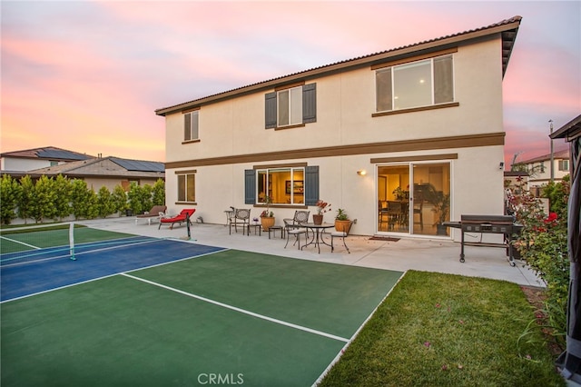 36275 Firelight Cir, Wildomar, CA 92595 - back of house at dusk featuring a tennis court, stucco siding, and a lawn