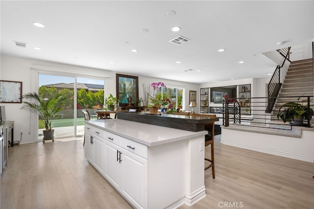 36275 Firelight Cir, Wildomar, CA 92595 - kitchen featuring a breakfast bar, light wood-style flooring, a center island, white cabinetry, and recessed lighting