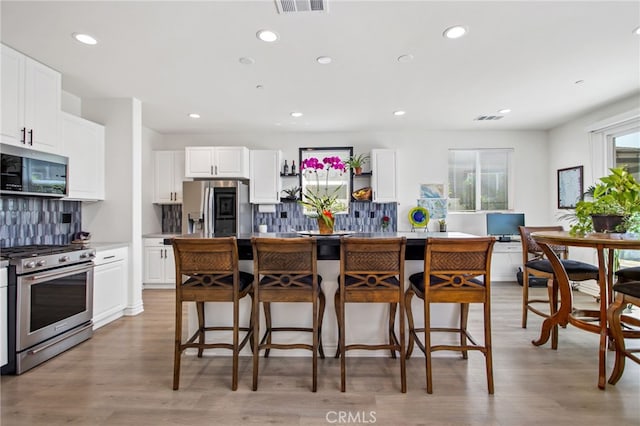 36275 Firelight Cir, Wildomar, CA 92595 - kitchen featuring stainless steel appliances, a kitchen bar, tasteful backsplash, recessed lighting, and white cabinets