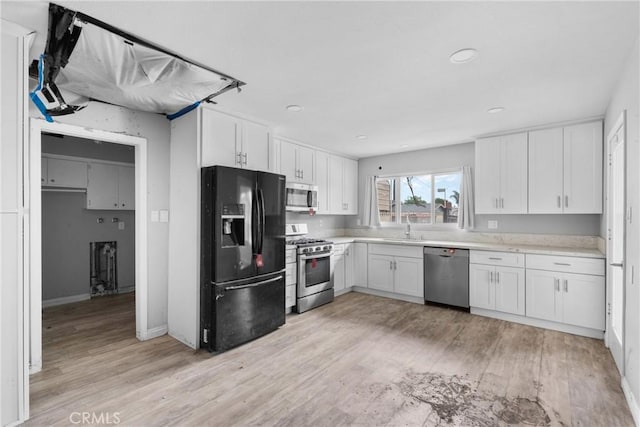 1754 N 1st Ave, Upland, CA 91784 - kitchen with appliances with stainless steel finishes, light wood-style flooring, white cabinets, light countertops, and recessed lighting