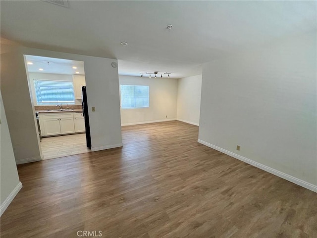 428 N Chapel Ave Unit B, Alhambra, CA 91801 - unfurnished room featuring baseboards, a sink, wood finished floors, rail lighting, and a pendent fire sprinkler