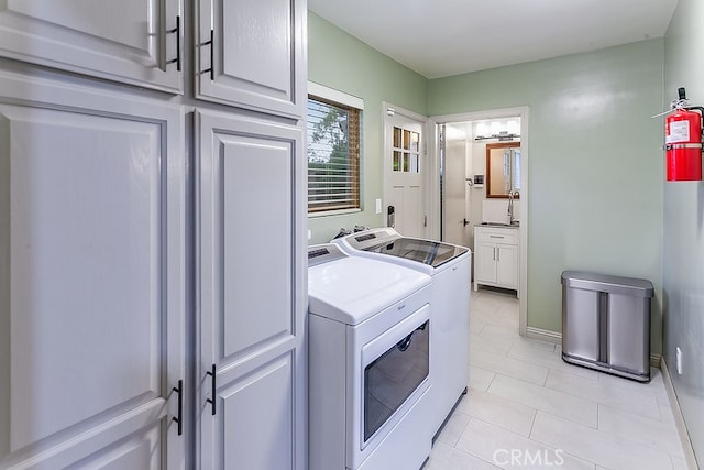 19520 Bermudas St, Porter Ranch, CA 91326 - washroom with washer and clothes dryer, cabinet space, and light tile patterned floors