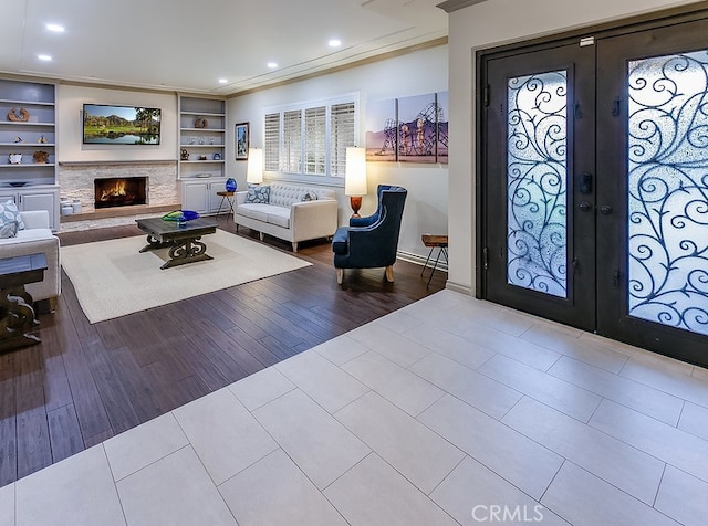 19520 Bermudas St, Porter Ranch, CA 91326 - entrance foyer with french doors, crown molding, recessed lighting, a lit fireplace, and tile patterned floors