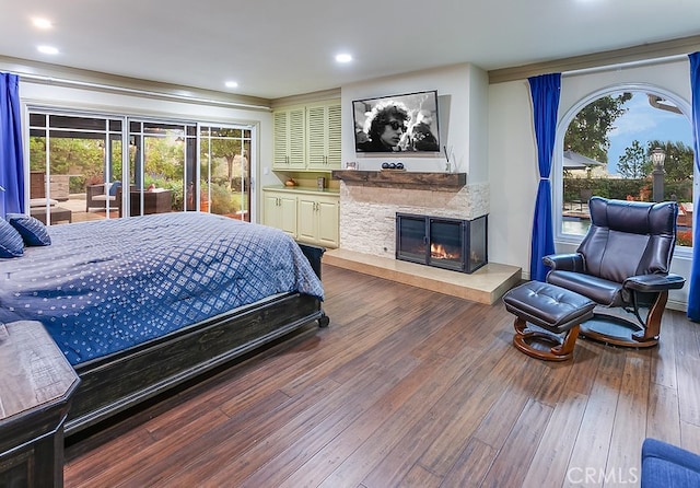 19520 Bermudas St, Porter Ranch, CA 91326 - bedroom featuring multiple windows, wood finished floors, a glass covered fireplace, recessed lighting, and access to outside