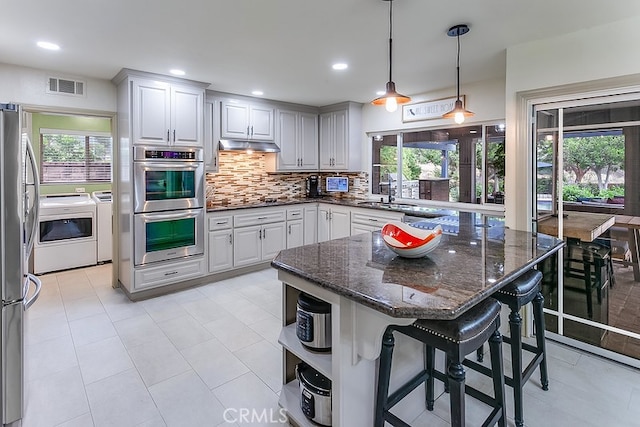 19520 Bermudas St, Porter Ranch, CA 91326 - kitchen featuring washer and clothes dryer, a sink, appliances with stainless steel finishes, decorative backsplash, and open shelves