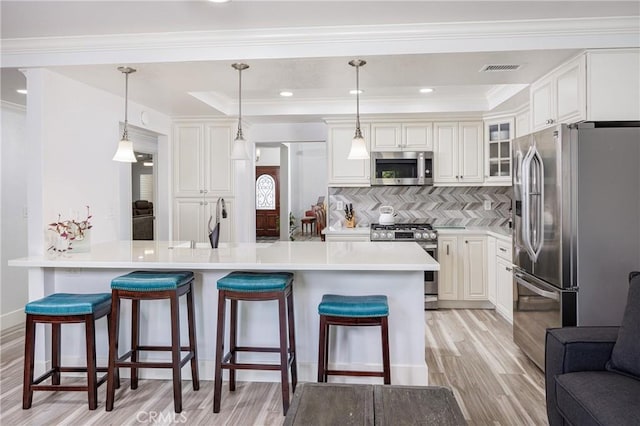 24711 Eloisa Dr, Mission Viejo, CA 92691 - kitchen featuring appliances with stainless steel finishes, light wood-style floors, a kitchen breakfast bar, glass insert cabinets, and backsplash
