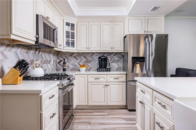 24711 Eloisa Dr, Mission Viejo, CA 92691 - kitchen featuring stainless steel appliances, light countertops, decorative backsplash, crown molding, and light wood-style floors