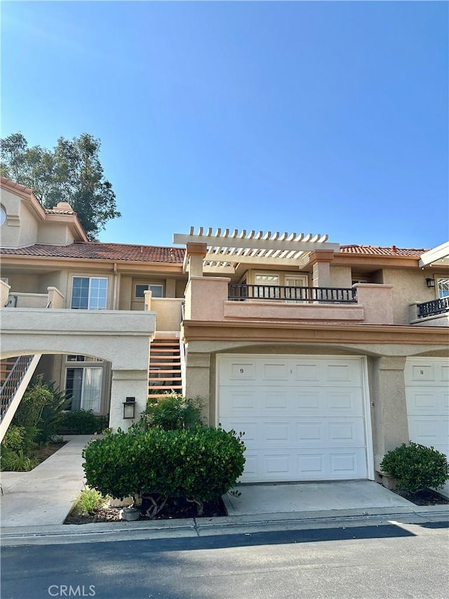 25843 Mcbean Unit 9, Valencia, CA 91355 - townhome / multi-family property featuring stucco siding, an attached garage, stairway, a balcony, and a tile roof