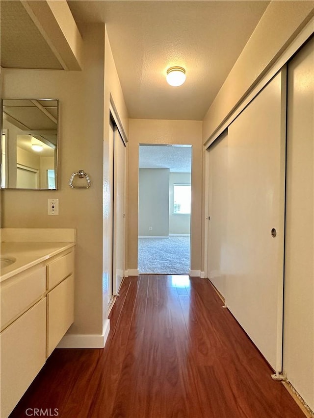 25843 Mcbean Unit 9, Valencia, CA 91355 - hallway featuring dark wood-type flooring and baseboards