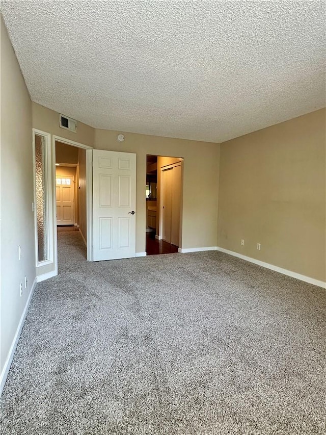 25843 Mcbean Unit 9, Valencia, CA 91355 - unfurnished bedroom featuring dark carpet, a textured ceiling, a closet, and baseboards