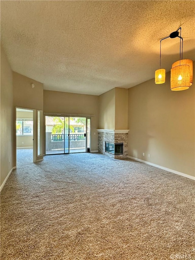 25843 Mcbean Unit 9, Valencia, CA 91355 - unfurnished living room featuring a textured ceiling, carpet floors, a glass covered fireplace, and baseboards