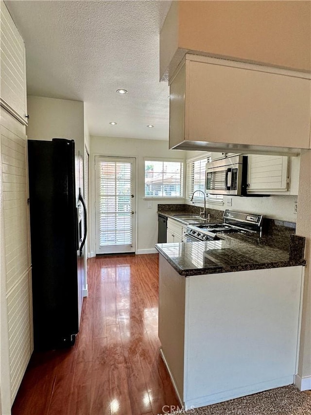 25843 Mcbean Unit 9, Valencia, CA 91355 - kitchen with black appliances, a sink, a peninsula, white cabinetry, and baseboards