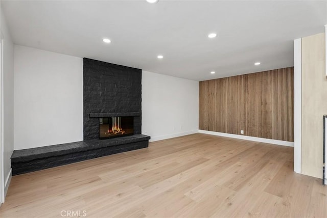 21692 Seaside Ln, Huntington Beach, CA 92646 - unfurnished living room featuring a fireplace, light wood finished floors, recessed lighting, baseboards, and wood walls
