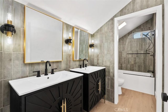 21692 Seaside Ln, Huntington Beach, CA 92646 - bathroom with tile walls, toilet, lofted ceiling, wood finished floors, and two vanities