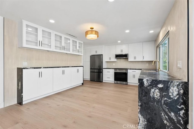21692 Seaside Ln, Huntington Beach, CA 92646 - kitchen featuring stainless steel appliances, a sink, decorative backsplash, light wood-style flooring, and white cabinetry
