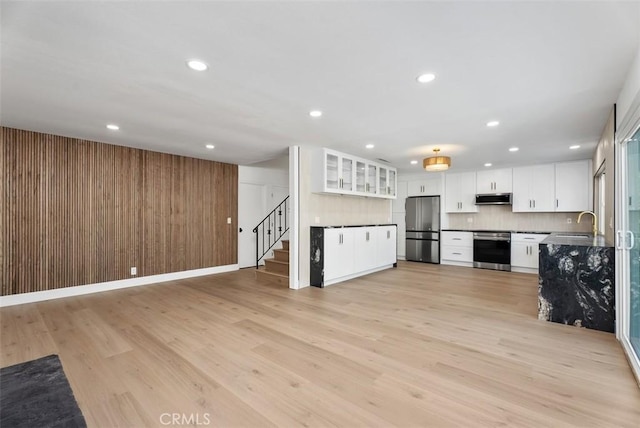 21692 Seaside Ln, Huntington Beach, CA 92646 - kitchen with appliances with stainless steel finishes, open floor plan, light wood-style floors, recessed lighting, and wooden walls
