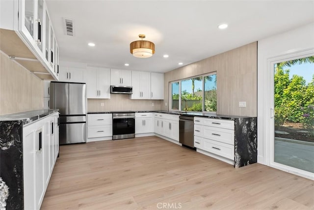 21692 Seaside Ln, Huntington Beach, CA 92646 - kitchen with appliances with stainless steel finishes, plenty of natural light, light wood-style floors, dark countertops, and recessed lighting