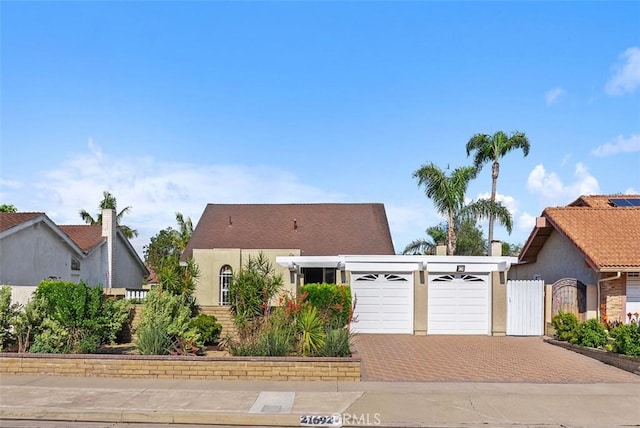 21692 Seaside Ln, Huntington Beach, CA 92646 - view of front of property featuring an attached garage, decorative driveway, stucco siding, and a gate