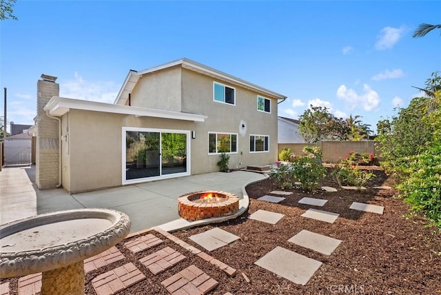 21692 Seaside Ln, Huntington Beach, CA 92646 - back of house with a fire pit, a patio area, stucco siding, and a chimney