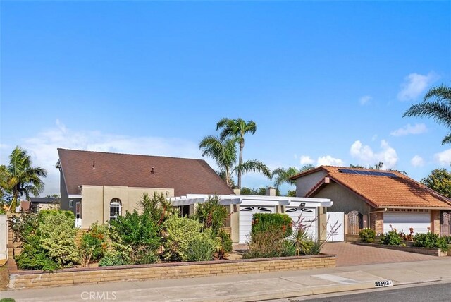 21692 Seaside Ln, Huntington Beach, CA 92646 - mediterranean / spanish-style home featuring decorative driveway, stucco siding, a gate, and solar panels